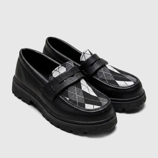 A side view of a Klevas black chunky sole loafer for boys, featuring a textured upper and a black and white argyle pattern
