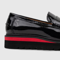 Babucci men's black patent leather slip-on loafer with a chunky red and black lug sole, shown in a close-up side view.