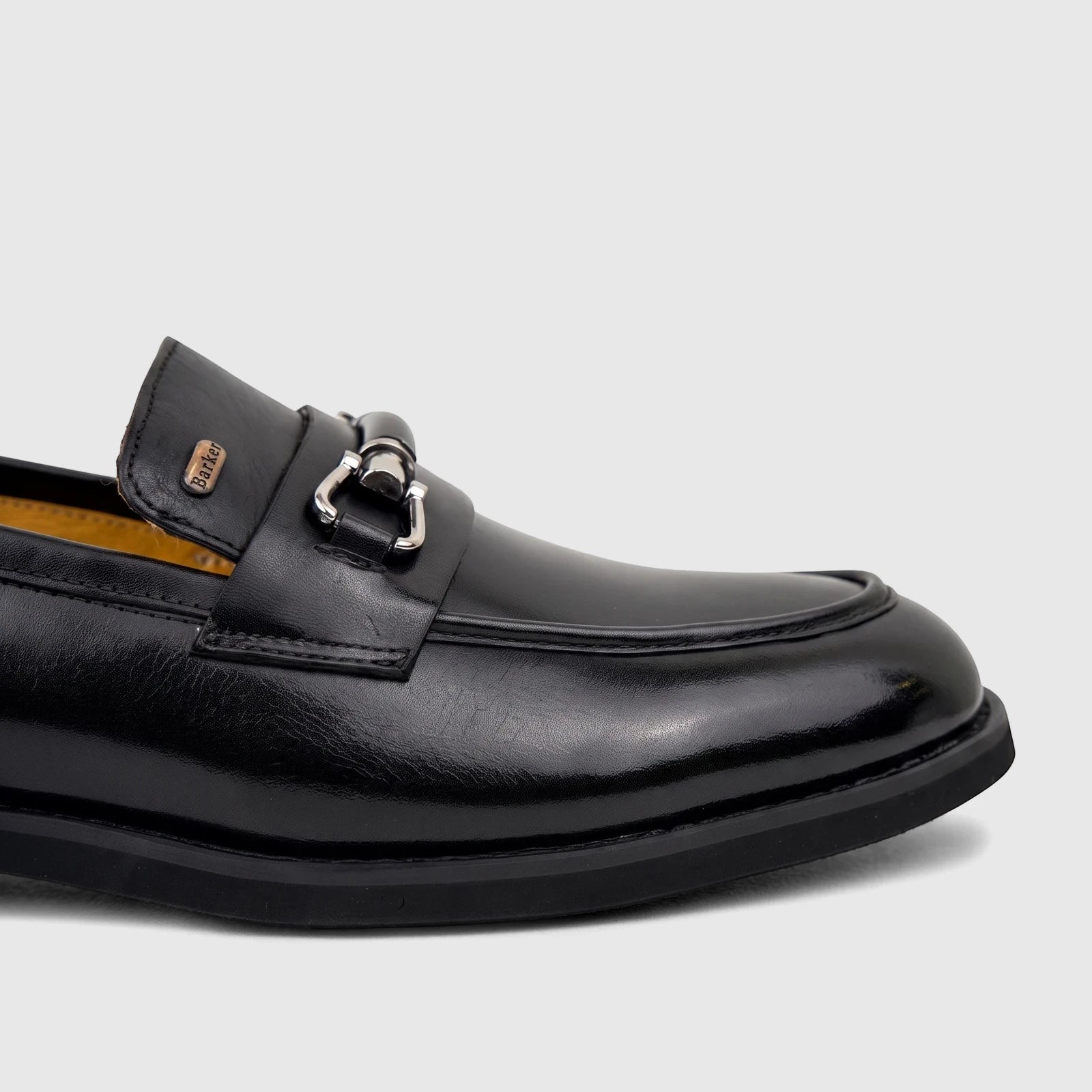 Black leather Barker men's dress slip-on loafer with a silver horse-bit detail, shown from a side view.