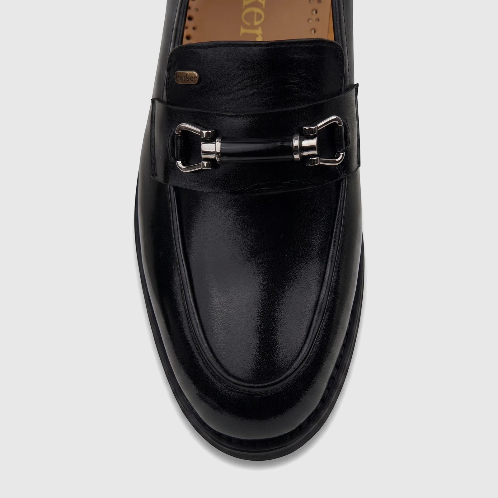 Close-up of a black leather Barker men's dress slip-on loafer with a polished silver-tone bit buckle on a white background.