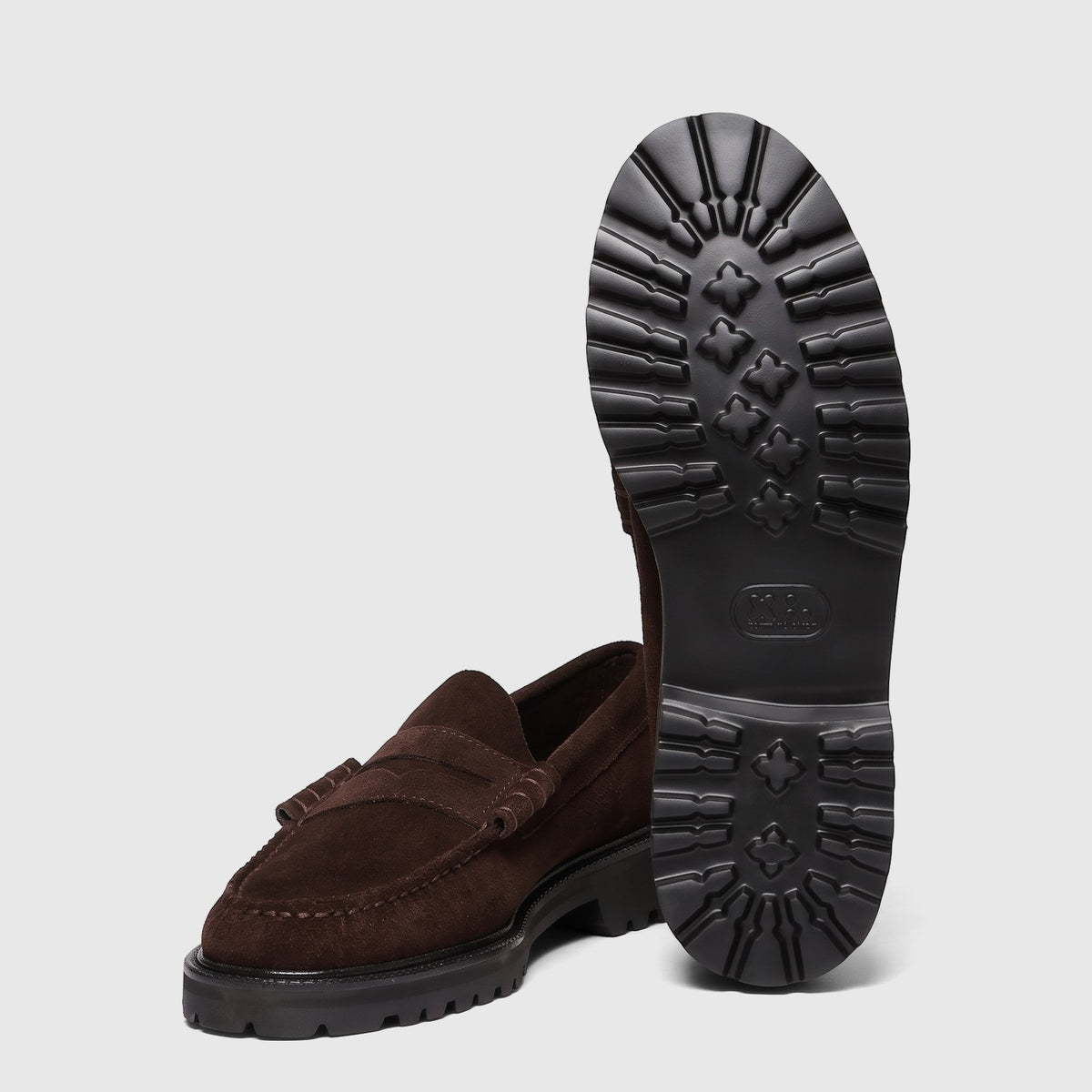 Chocolate suede men's chunky sole loafers, featuring one shoe upright to display its lug sole and another lying on its side.