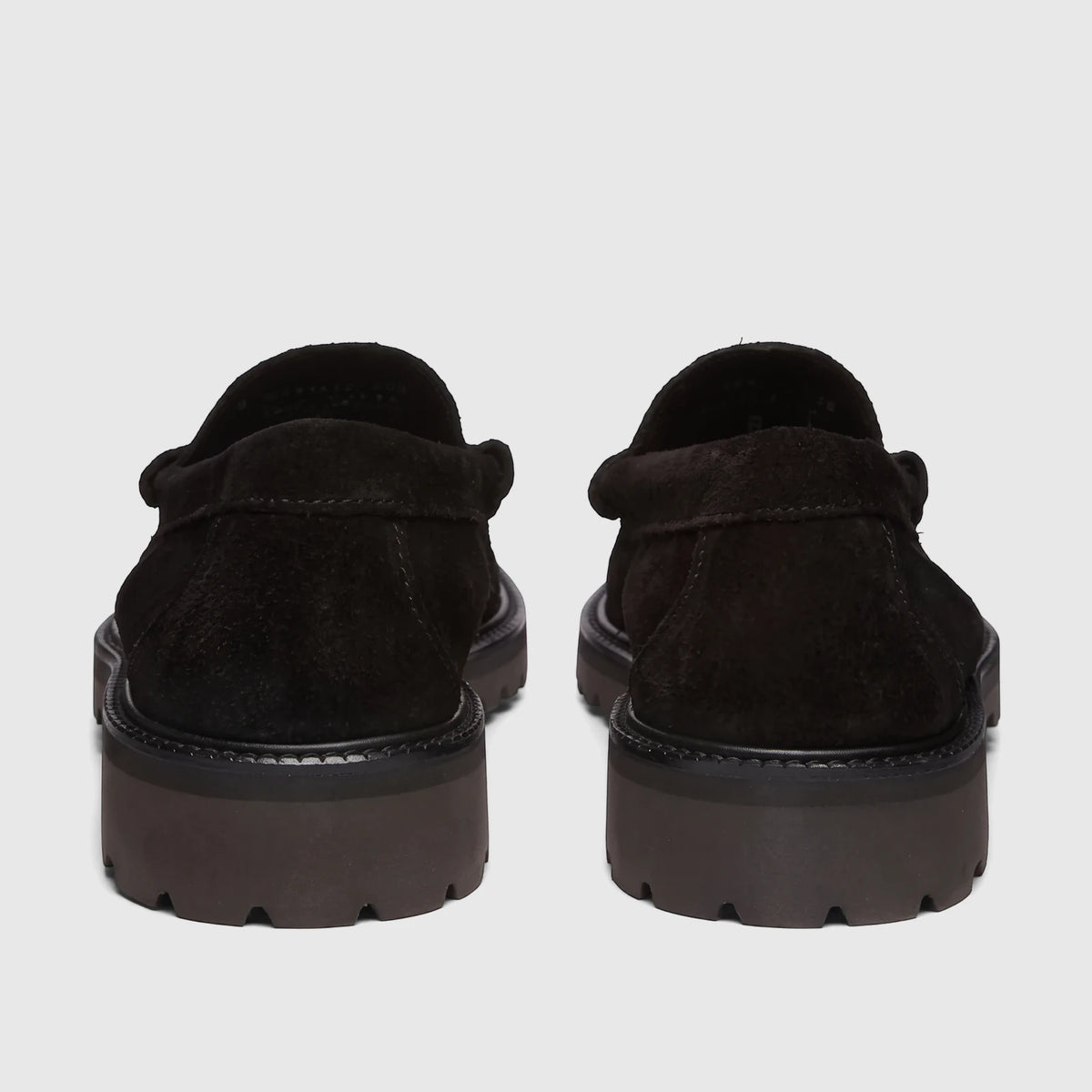 Rear view of two black suede Bass Men's Weejun Lug Larson chunky sole loafers, showing textured soles.