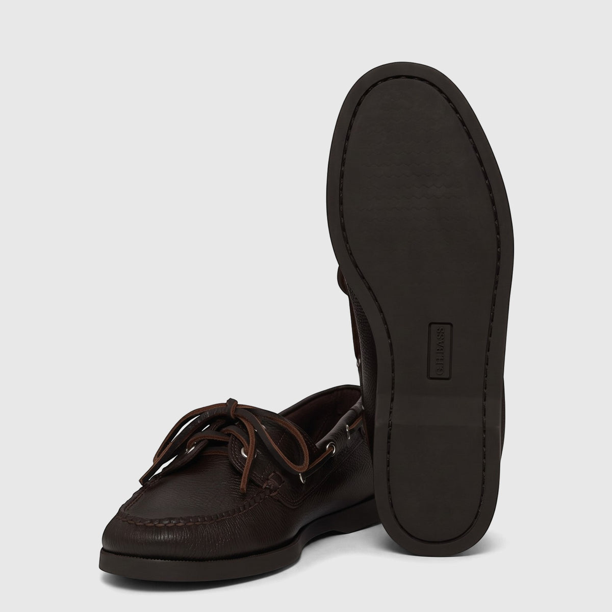 Dark brown textured leather Bass Men's Jetty II Boater 2 Eye boat shoes, one upright and one on its side, studio shot.
