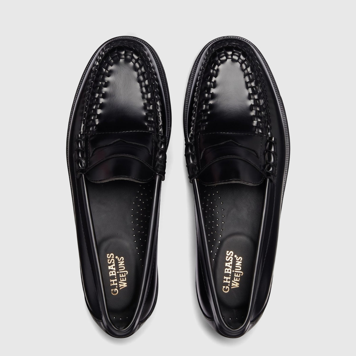Pair of black leather Bass Men's Larson Weave BA11010F 00X loafers, featuring detailed woven vamp, seen from a top-down