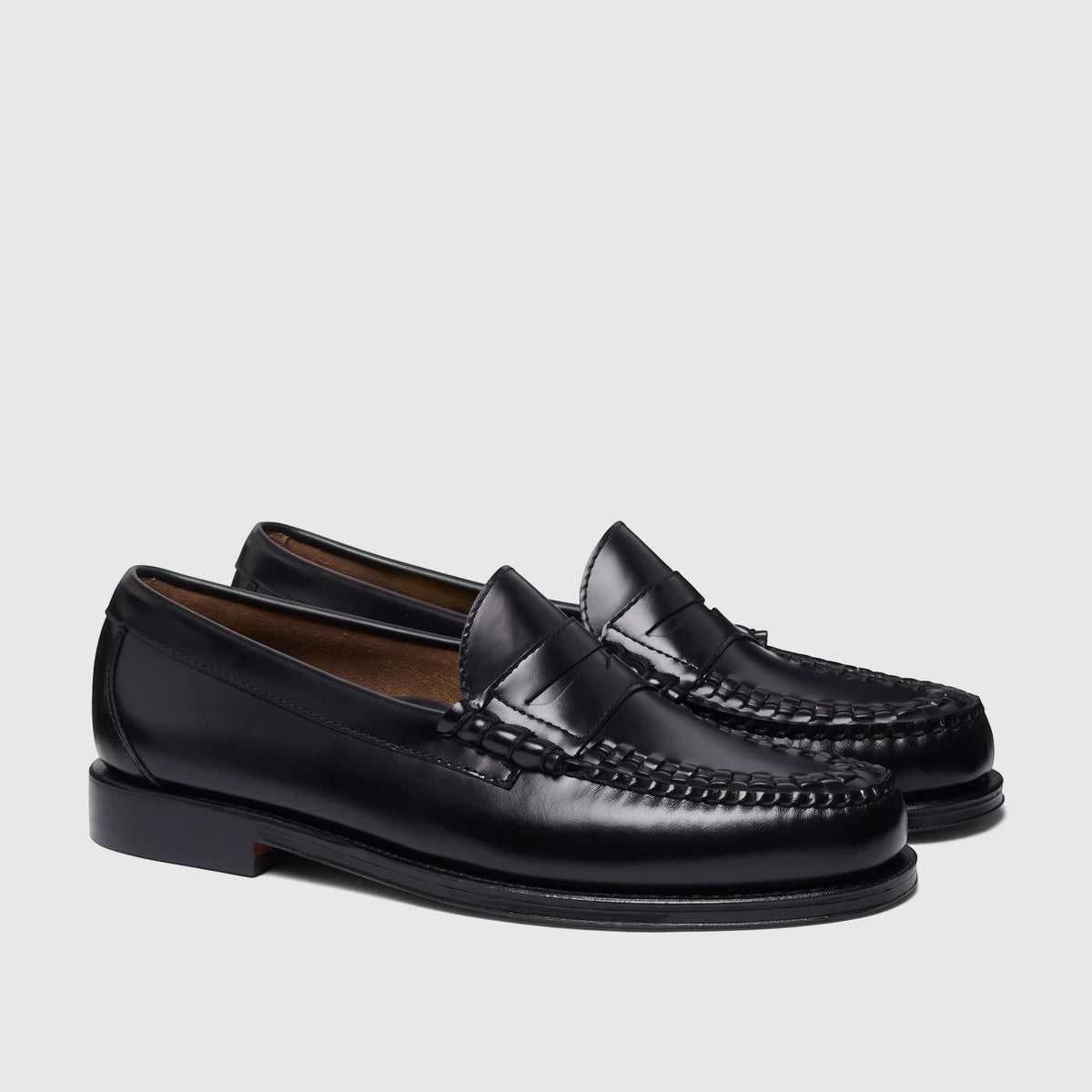 A pair of men's black leather Bass Larson Weave penny loafers with intricate woven details on the vamp.