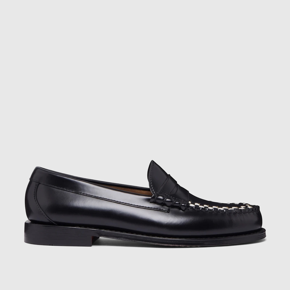 Black leather men's penny loafer with distinctive white woven details on the vamp, shown from a side angle.
