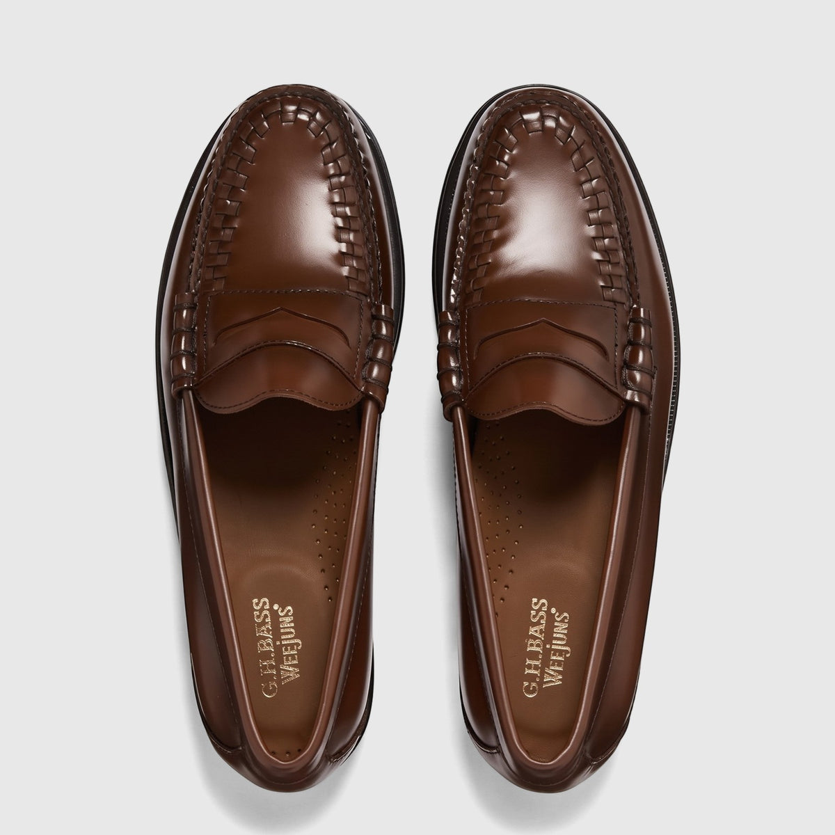 Pair of G.H. Bass Weejuns men's Larson Weave penny loafers in mid-brown polished leather, shown from an overhead view.