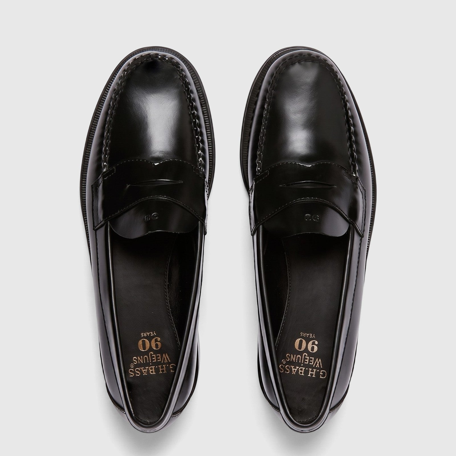 Top-down view of a pair of men's G.H. Bass Weejun Logan penny loafers in shiny black leather, showcasing the classic design