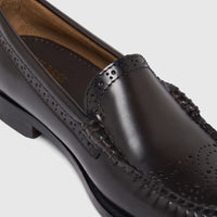 Close-up of a single men's Bass Weejun Venetian Brogue black leather loafer with perforated details on the vamp.