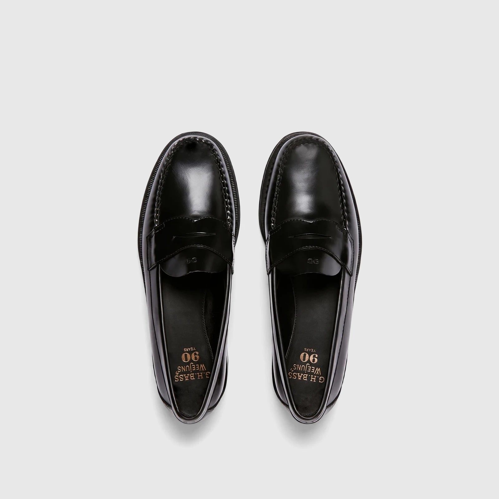 A pair of black leather Bass Weejun Logan penny loafers, viewed from above on a white background.