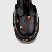 Top view of a black Bulbul Ladies Block Heel with T Bar shoe, featuring intricate brown and beige floral embroidery.