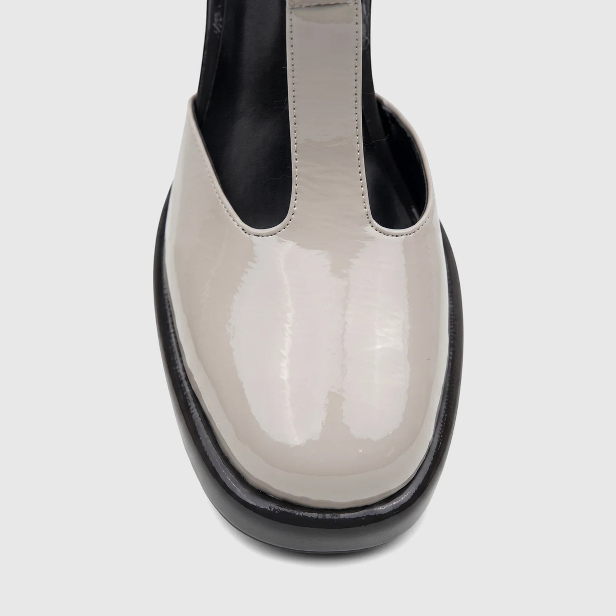 Bulbul Ladies Block Heel T-Bar shoe in off-white patent leather with a black sole, shown from a front close-up view.