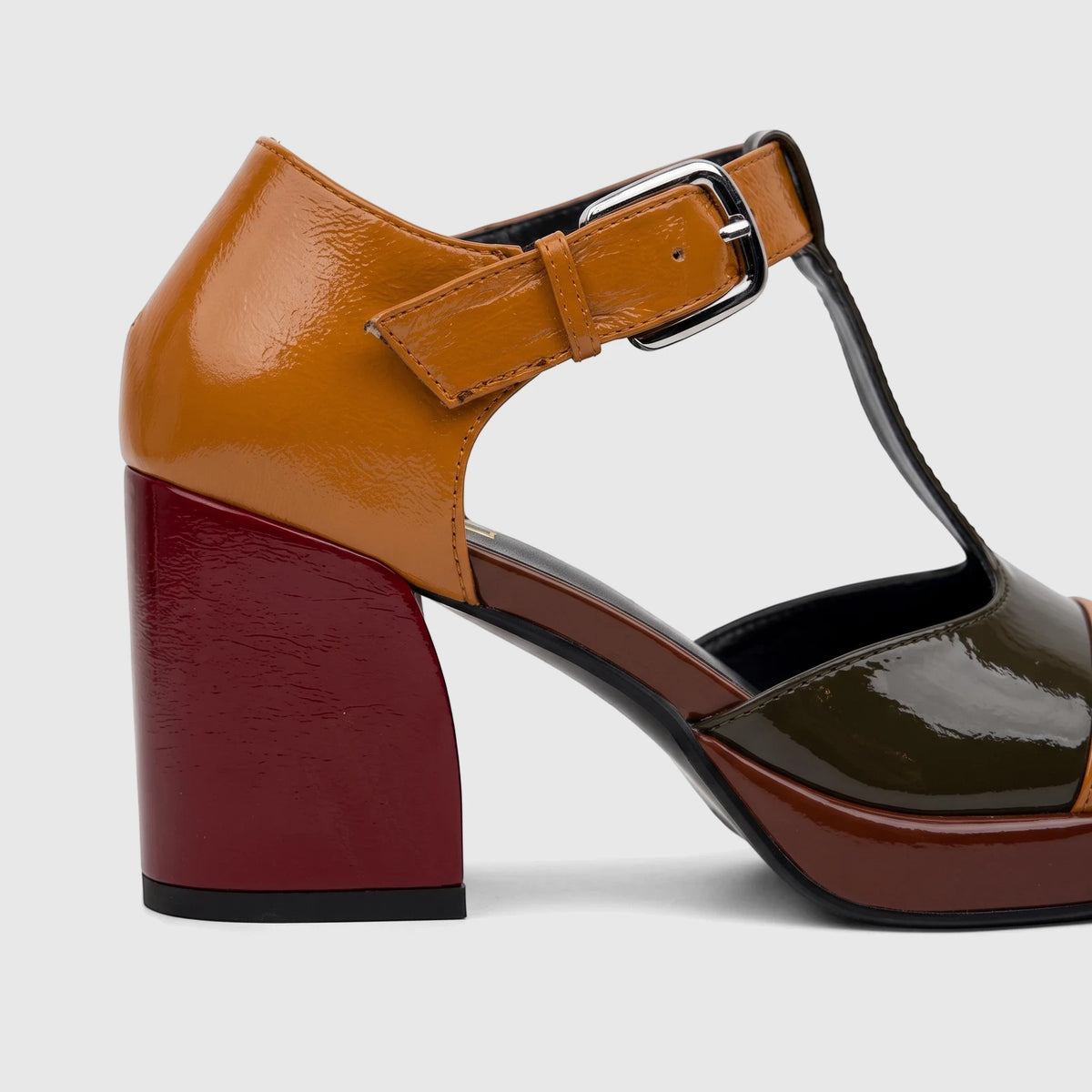 Ladies Bulbul block heel shoe with T-bar strap in glossy brown, orange, and red patent leather.