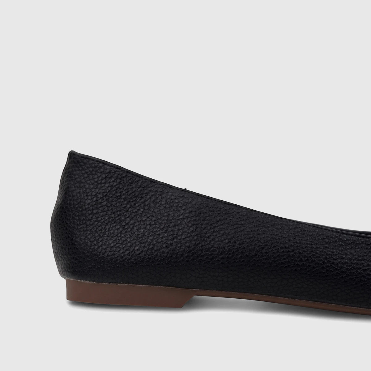 Side view of a black Bulbul Ladies Casual Pump shoe, featuring a pebbled texture and a subtle brown sole, ideal for everyday
