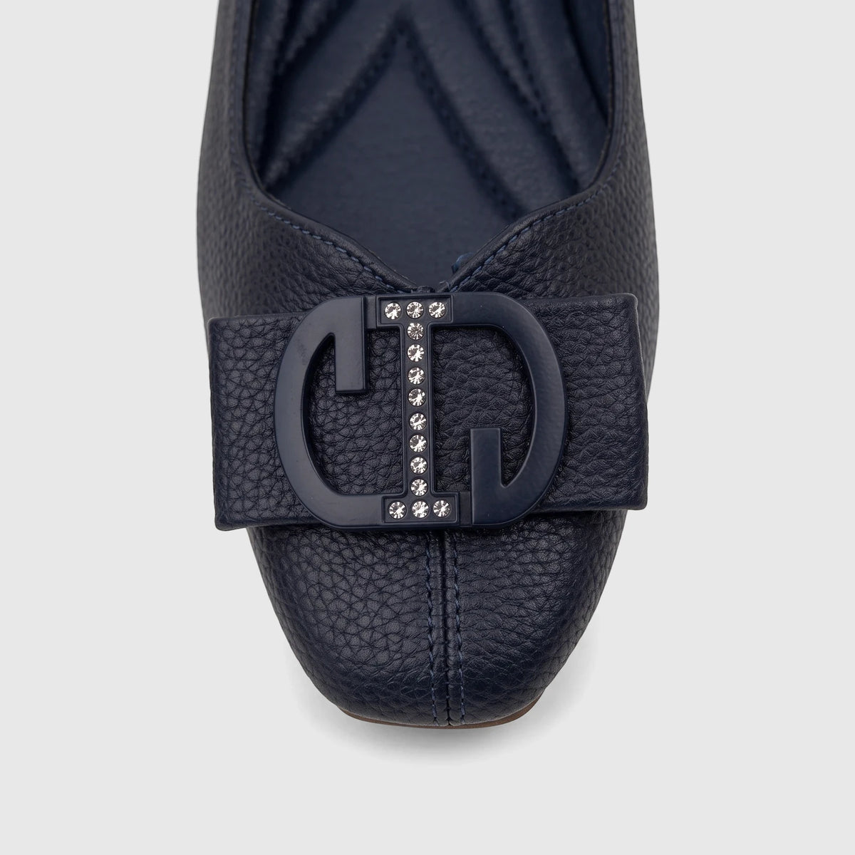 Close-up of a navy blue textured leather Bulbul Ladies Casual Pump with a prominent 'CD' logo buckle embellished with