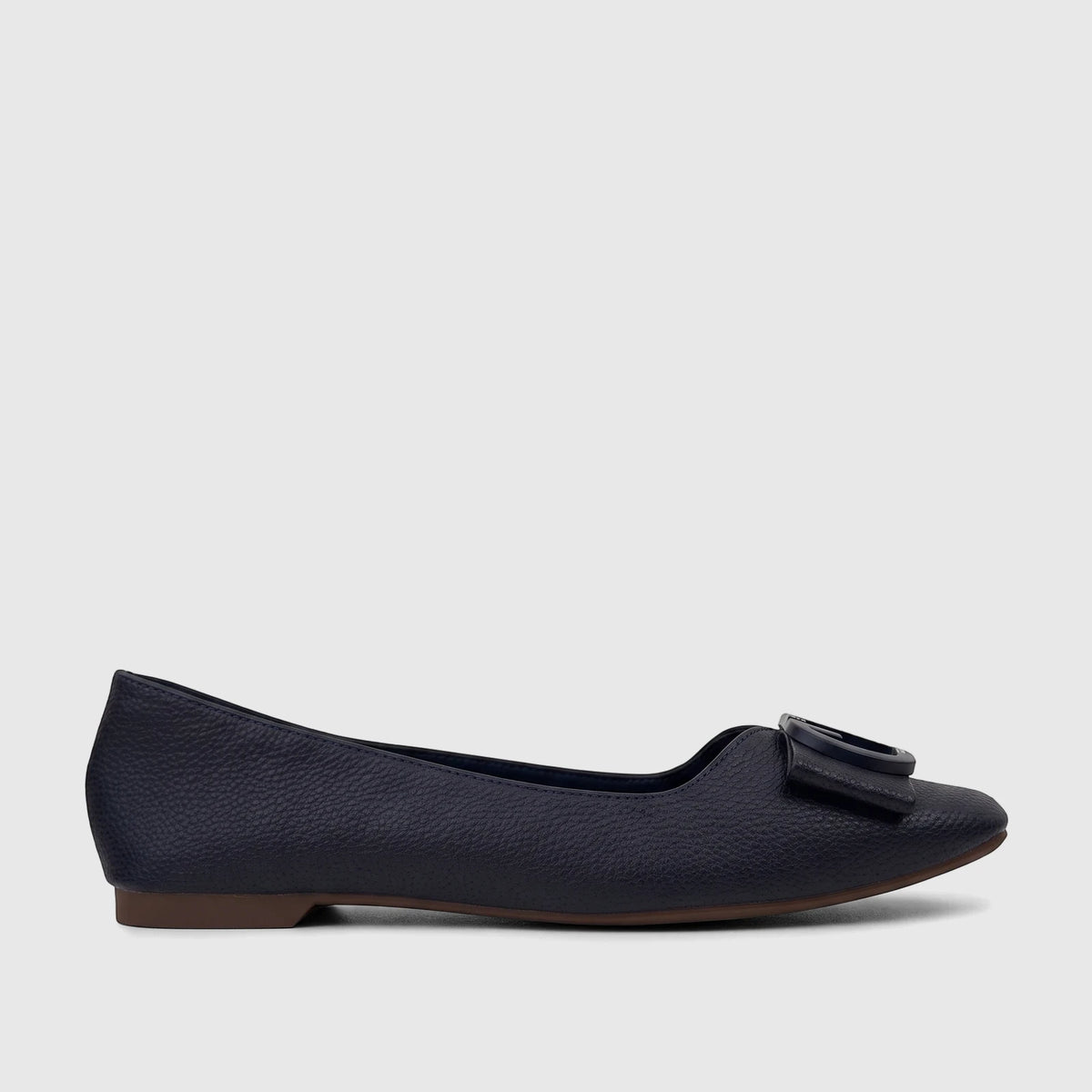 Side profile of a Bulbul Ladies Casual Pump in navy, featuring a textured upper, decorative buckle, and brown sole.
