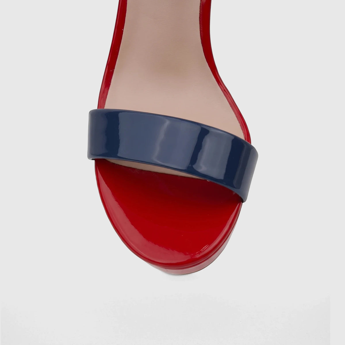 Close-up front view of a Bulbul Ladies Casual Slingback Sandal featuring glossy red and navy blue patent leather straps and