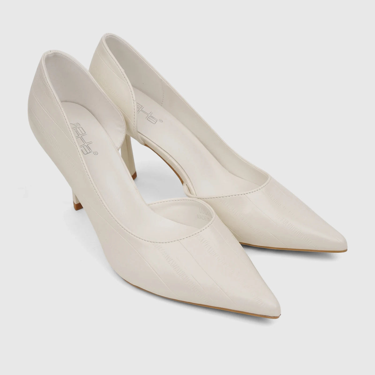 Pair of cream pointed-toe open waist court shoes for ladies, made with textured material, shown from a slightly elevated