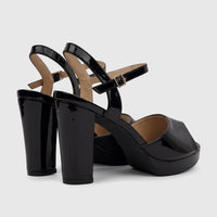Bulbul Ladies Dress black patent block heel sandals with ankle straps and open toe design, viewed from a rear angle.