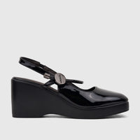 Black patent leather Bulbul Ladies Dress Block Heel Sandal, side view. Features closed-toe pump, wedge platform, and