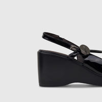 Close-up of a black patent leather Bulbul ladies dress block heel sandal, featuring a glossy finish and a dark metallic