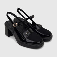 A pair of black patent leather Bulbul Ladies Dress Block Heel Sandals, featuring a square toe and gold buckle, displayed
