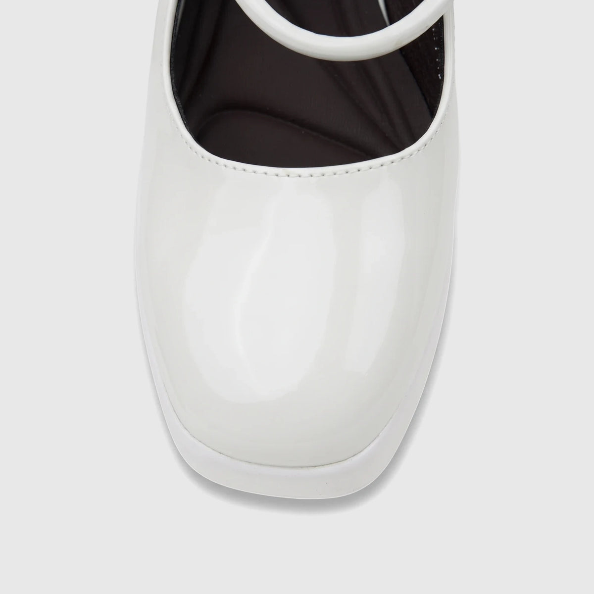 Close-up of a white patent leather Bulbul Ladies Dress Block Heel Sandal, showcasing the glossy finish and toe.