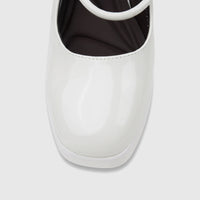 Close-up of a white patent leather Bulbul Ladies Dress Block Heel Sandal, showcasing the glossy finish and toe.