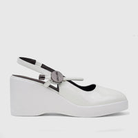 White patent leather Bulbul ladies dress block heel sandal, side view with metallic strap hardware.