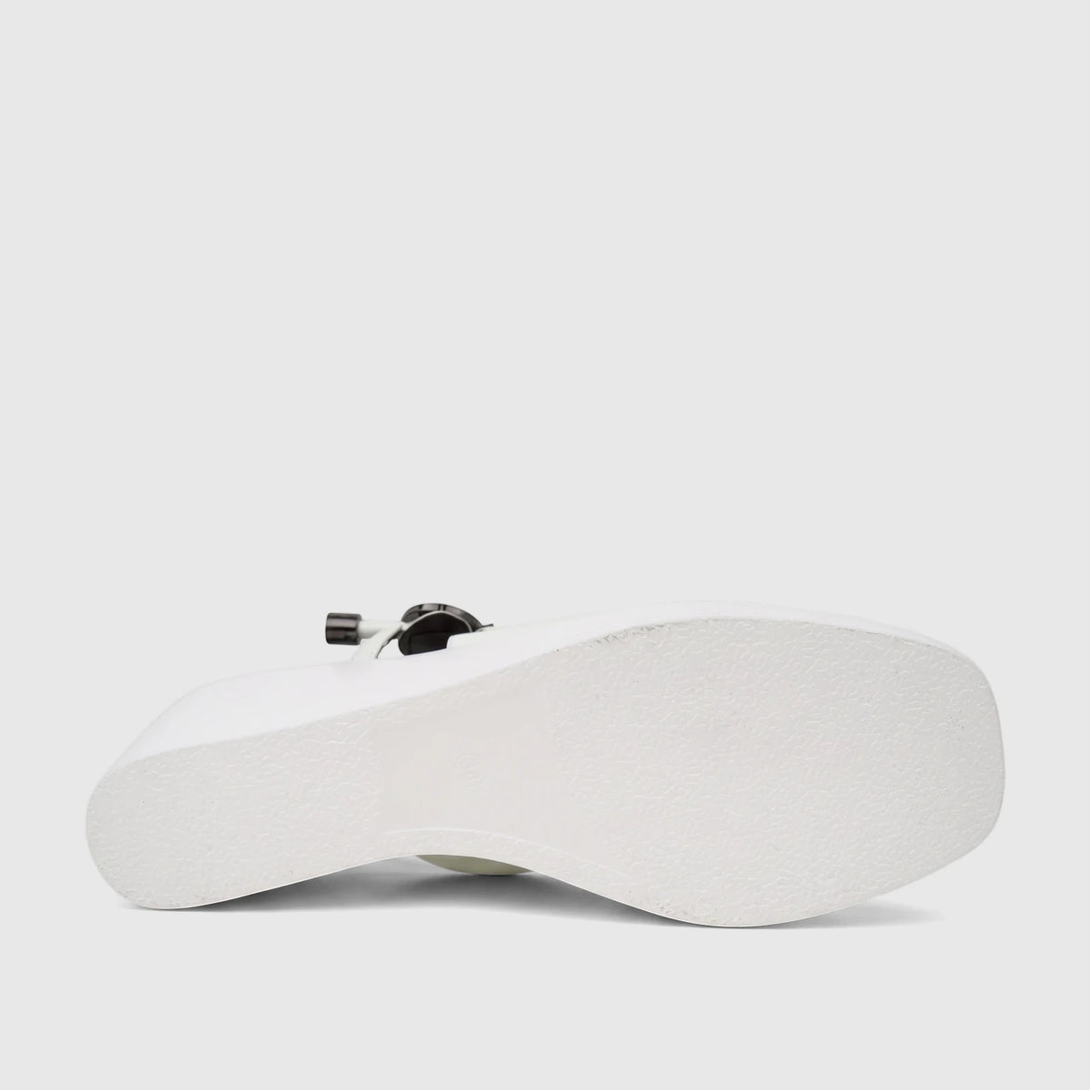 Close-up of a white Bulbul Ladies Dress Block Heel Sandal, showcasing its textured sole and side profile from a low angle on