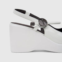 Bulbul Ladies Dress Block Heel Sandal in white patent leather, featuring a high wedge heel and ankle strap, close-up side