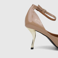 Close-up of a beige patent leather ladies' dress court shoe with an ankle strap and a distinctive gold high heel.