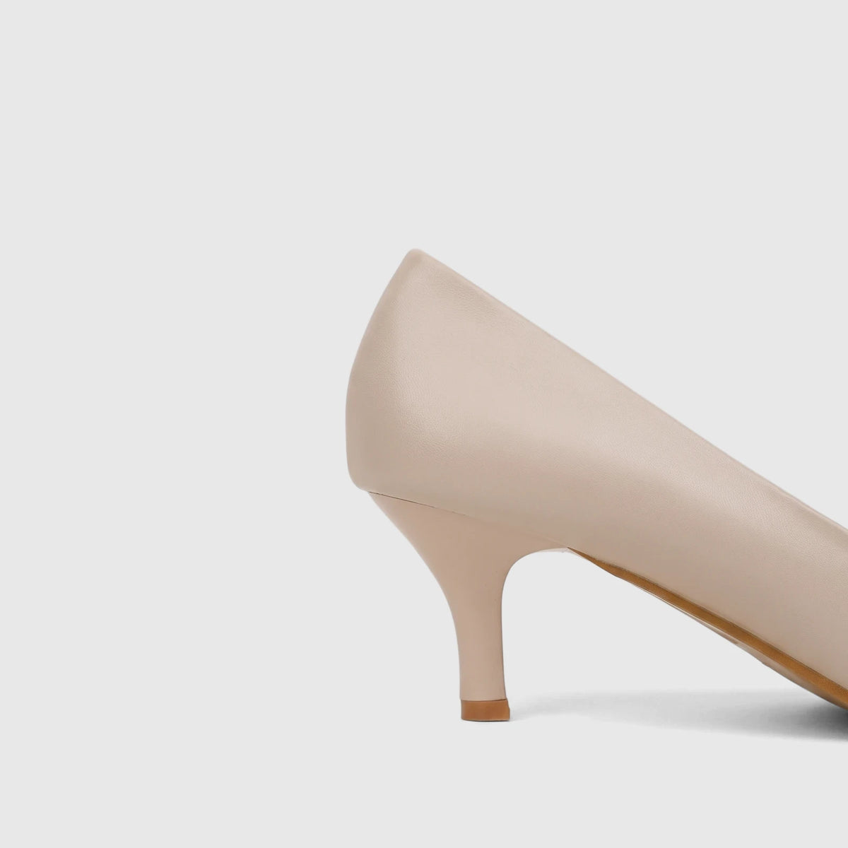 Beige Bulbul ladies dress court shoe with a kitten heel, shown from a side and back view, highlighting its smooth texture.