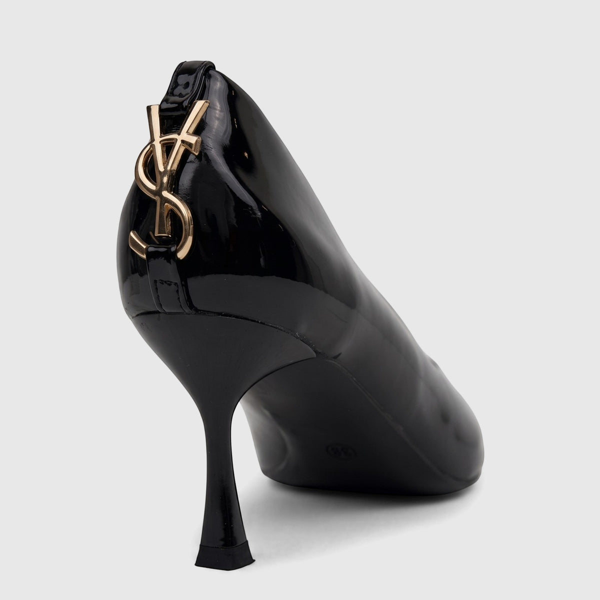 Black patent leather Bulbul Ladies Dress Court Shoe with a high heel and golden YSL logo on the back, shown from a rear-side