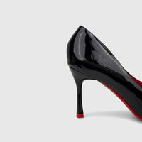 Close-up of a black patent leather Bulbul Ladies Dress Court Shoe with a high heel and distinct red sole.