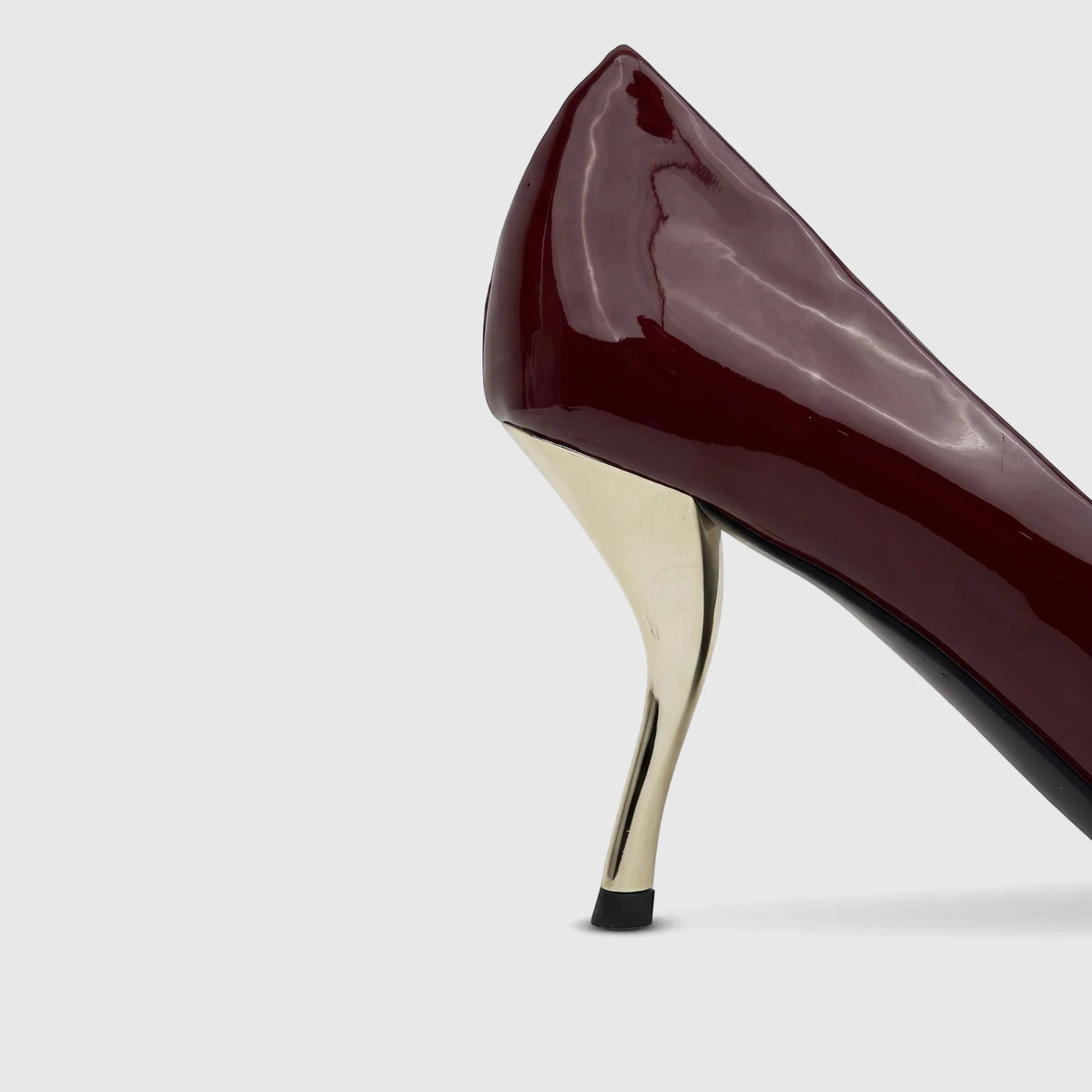 Close-up of a burgundy patent leather Bulbul Ladies Dress Court Shoe with a distinctive gold sculpted heel.