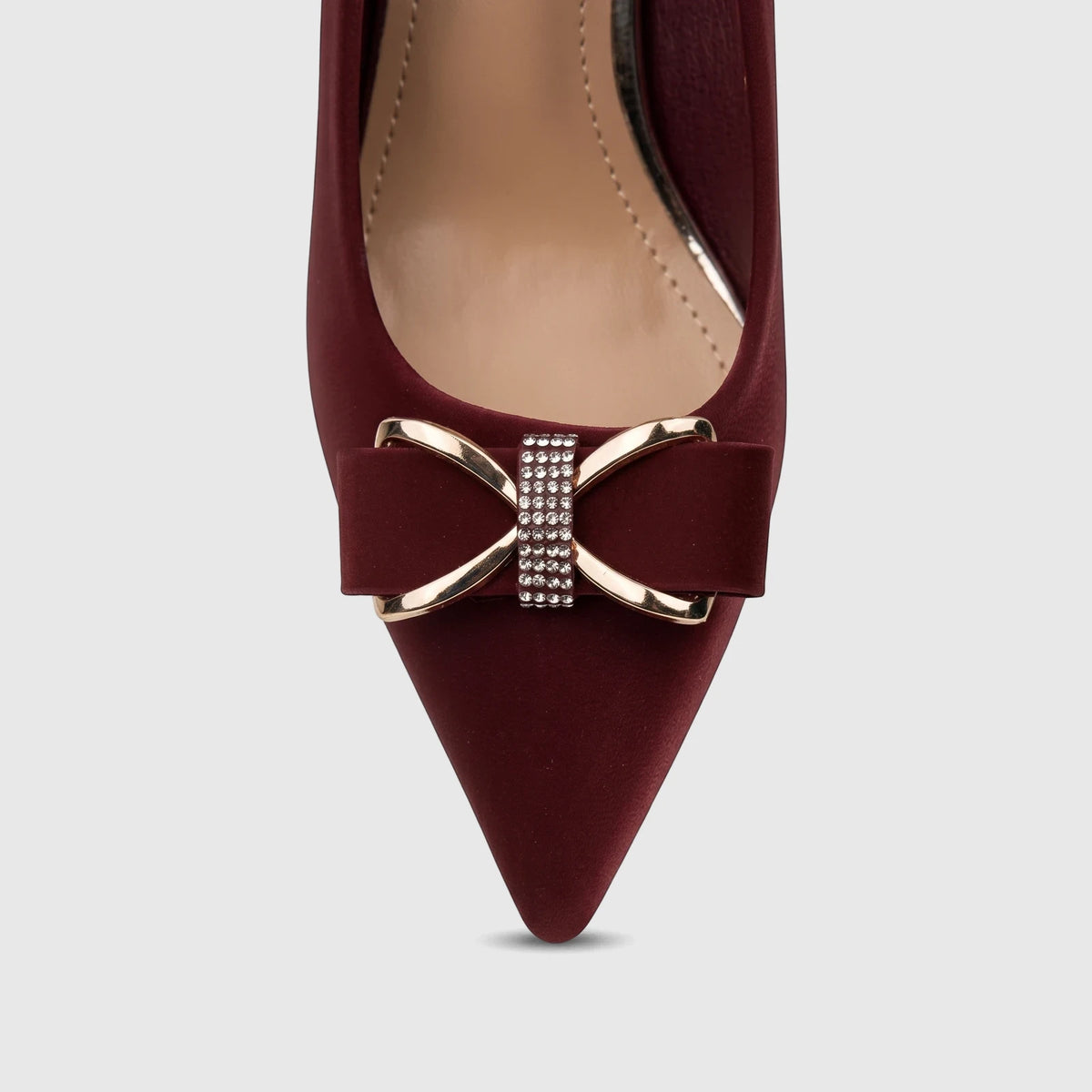 Front view of a burgundy Bulbul Ladies Dress Court Shoe, featuring a pointed toe and a gold-tone bow buckle adorned with