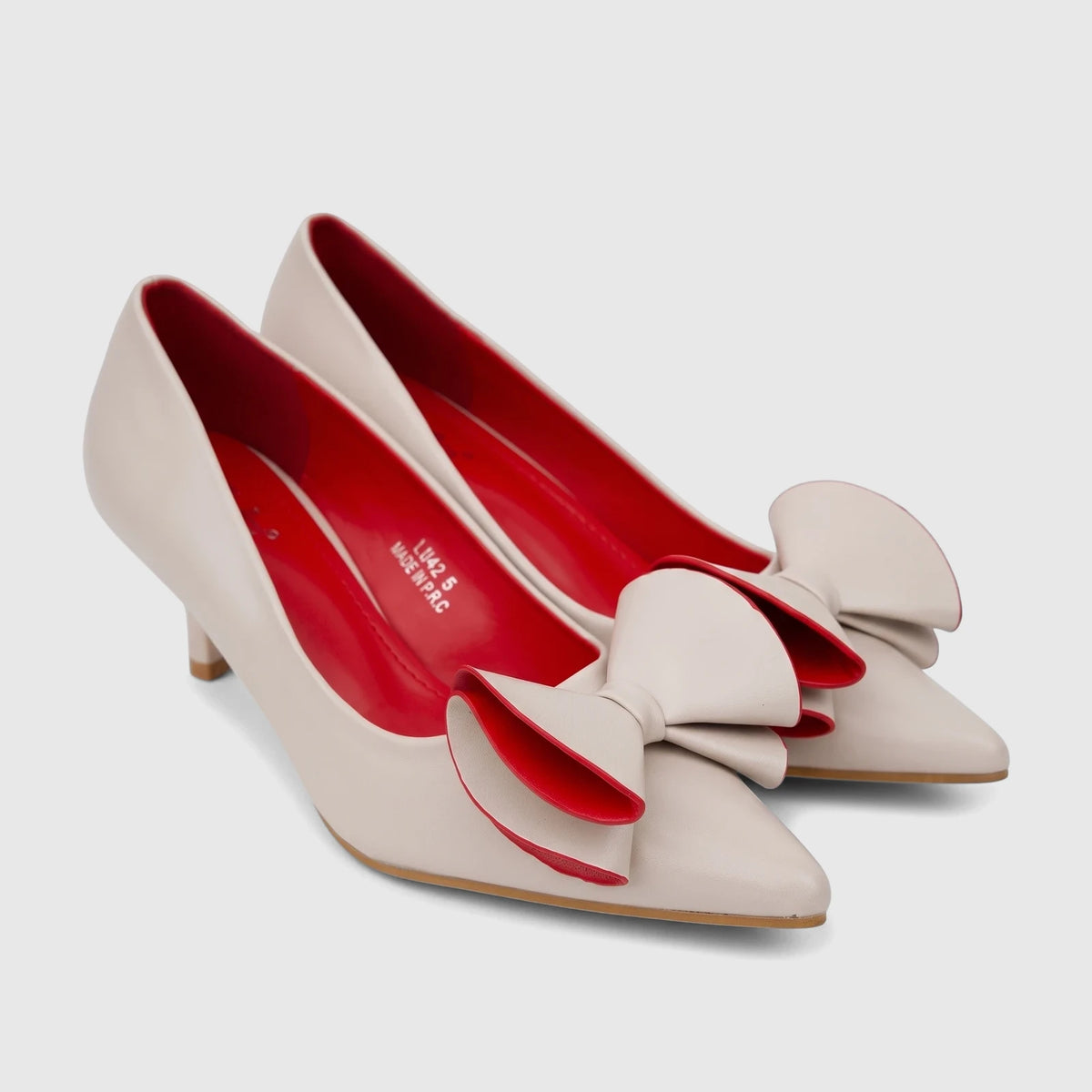Pair of beige Bulbul Ladies Dress Court Shoes, featuring pointed toes, kitten heels, and decorative bows with red accents.