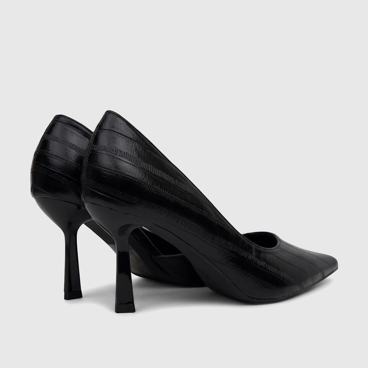 A pair of black Bulbul Ladies Dress Open Waist Court Shoes, glossy with high heels, viewed from a rear-quarter angle on a