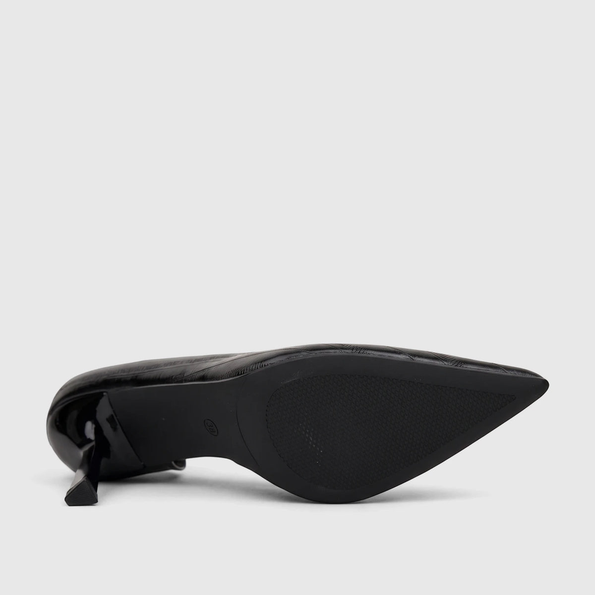 Black patent leather ladies dress court shoe with a pointed toe and block heel, viewed from the sole showing textured grip.