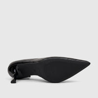 Black patent leather ladies dress court shoe with a pointed toe and block heel, viewed from the sole showing textured grip.