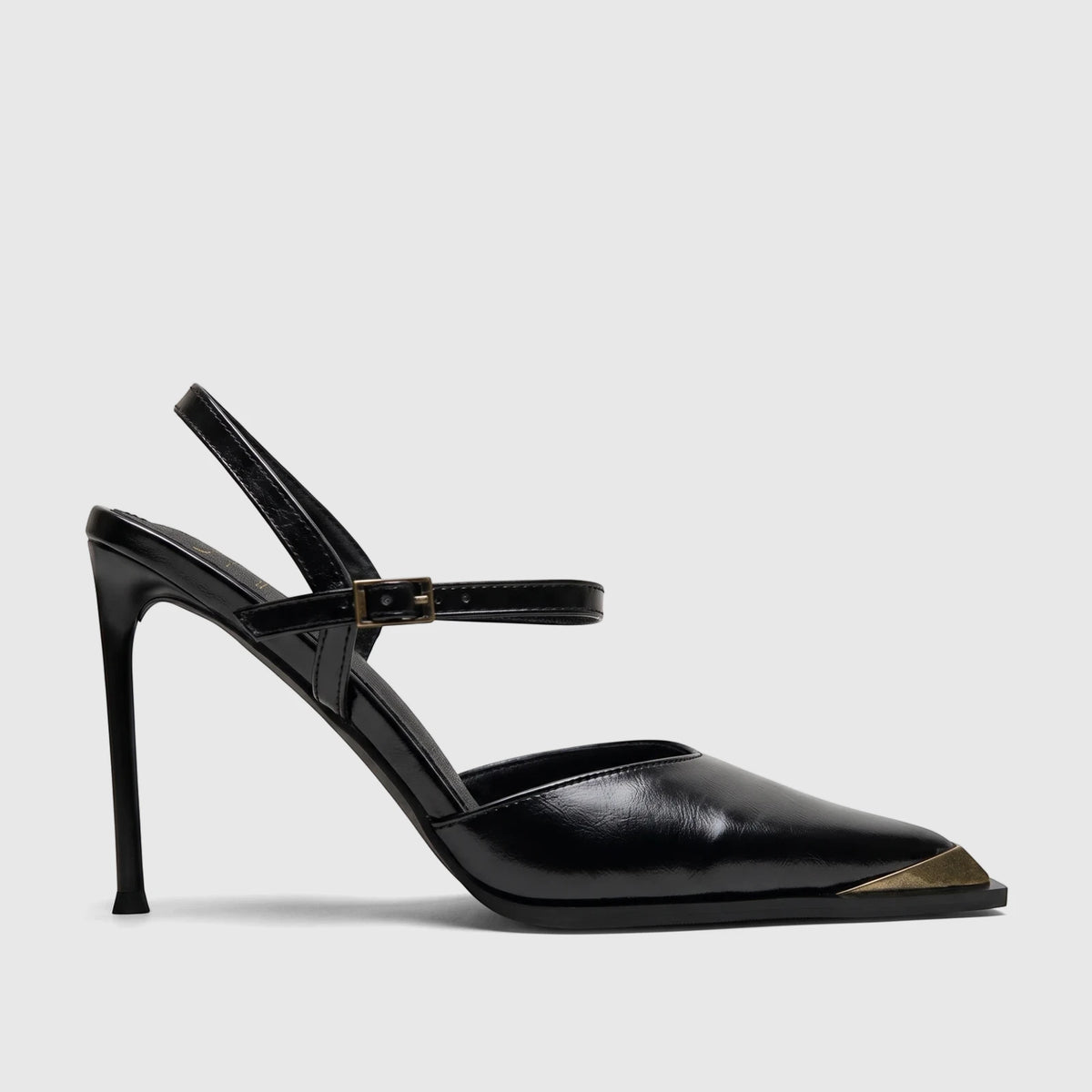 A black high-heeled slingback court shoe with a pointed toe and gold metal cap, featuring a stiletto heel and adjustable