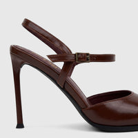 Brown patent leather high-heeled slingback court shoe with an ankle strap and buckle, shown from a side perspective.