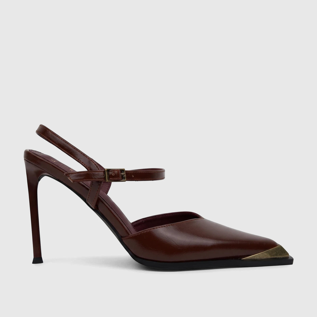 Brown patent leather slingback court shoe with a stiletto heel and gold-tone square toe cap on a light background.