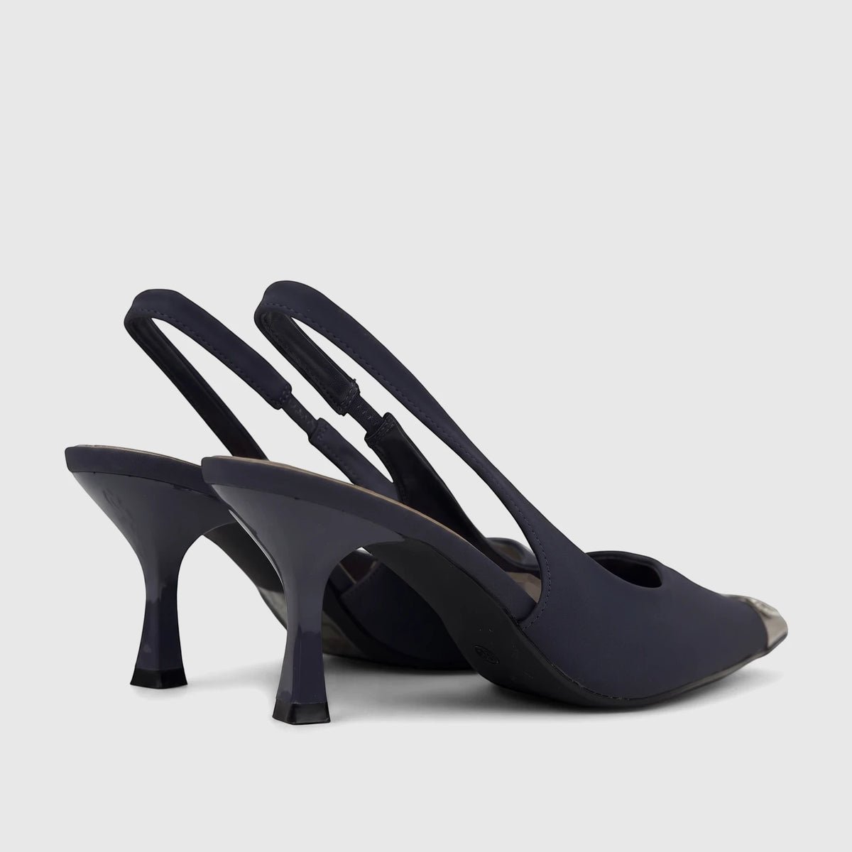 Two navy blue women's slingback court shoes featuring kitten heels, clear ankle straps, and stylish silver toe caps.