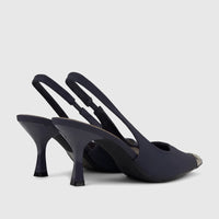 Two navy blue women's slingback court shoes featuring kitten heels, clear ankle straps, and stylish silver toe caps.