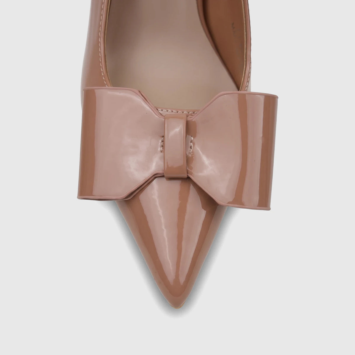 Close-up view of a Bulbul Ladies Dress Slingback Court in nude patent leather, featuring a pointed toe and a large