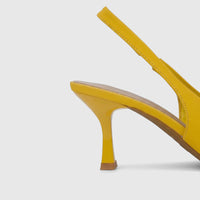 Close-up of a vibrant yellow ladies' dress slingback court shoe, showcasing its flared high heel and slingback strap on a