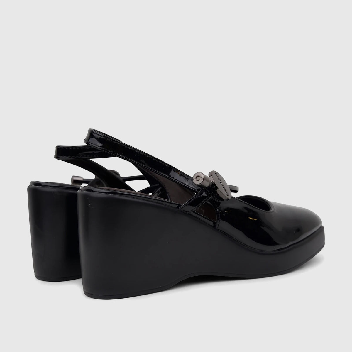 A pair of black patent leather Bulbul Ladies Dress wedge heel sandals with slingback straps, positioned at a side-back view.