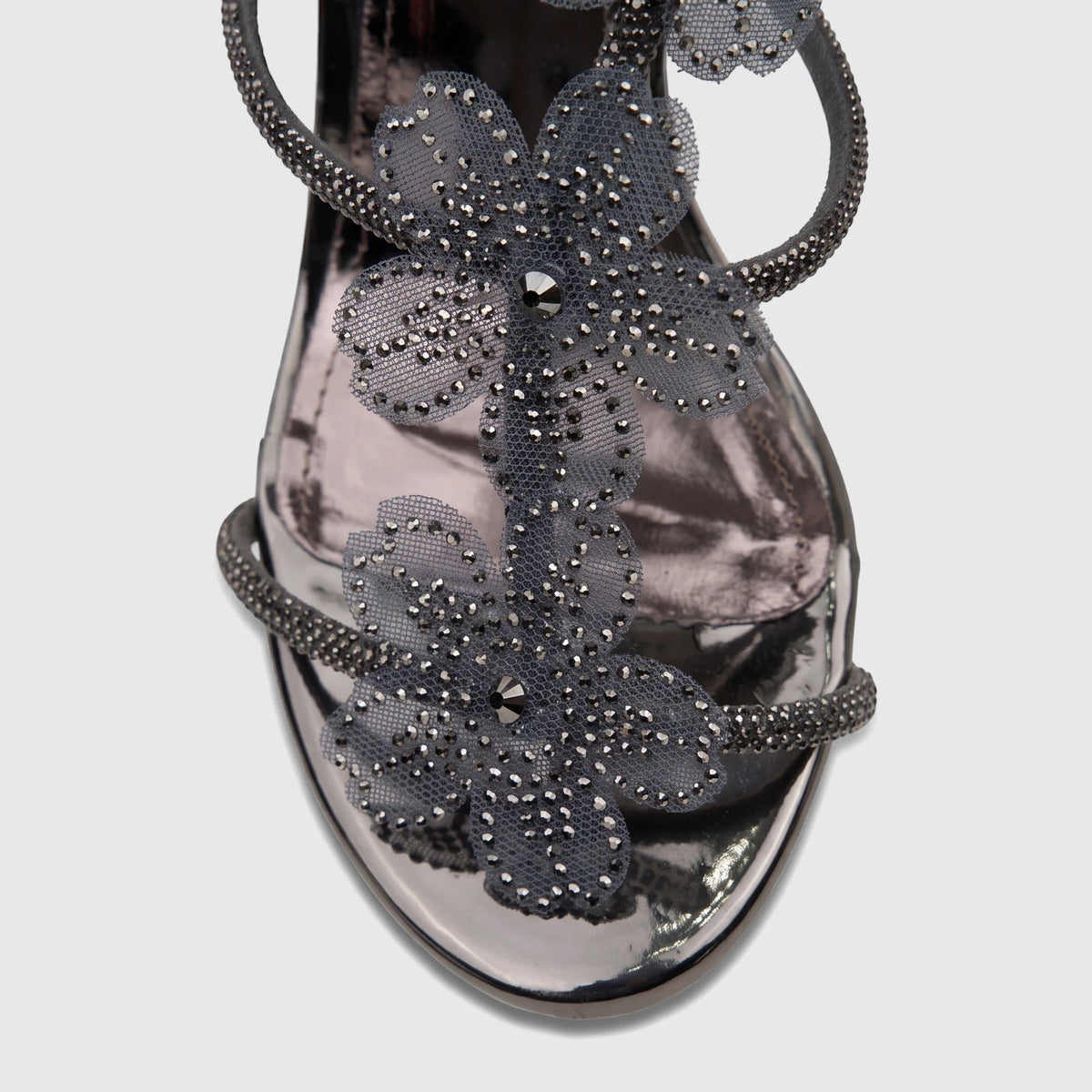 Close-up of a Bulbul Ladies Evening Block Heel Sandal in gunmetal with sparkling floral mesh details on a metallic finish.